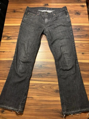 Svarta bootcut jeans från Levi's - Säljer ett par svarta urtvättade Levis 517 bootcut jeans från Levi's. Jeansen har en avslappnad passform (Bootcut) och är tillverkade i denim. Perfekta för en cool och avslappnad stil. W 34 L 32. Skriv gärna vid mått eller andra funderingar.