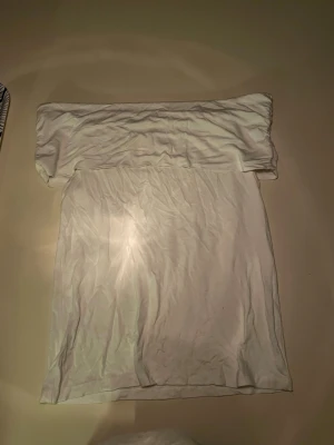 Vit offshoulder topp från Amisu - Säljer en vit offshoulder topp från Amisu i storlek L men passar både s och xs. Toppen är ärmlös och har en bred kant upptill som ger en snygg och trendig look. Perfekt att matcha med jeans eller kjol för en fräsch stil.