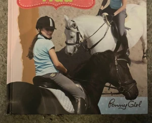 Börja rida - Penny Girl bok - En färgglad bok med hårt omslag från Penny Girl-serien. Boken heter 'Börja rida' och handlar om grunderna i ridning, hur man sadlar, tränsar och rider hästar.