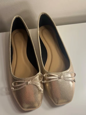 Guldiga Ballerinaskor - köpte av en tjej här på plick men var tyvärr för stora🩷hon sa aldrig något märke