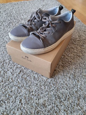 Paul Smith Lee Suede sneakers Grå - Riktigt feta gråa Paul Smith sneakers i storlek 43. Modell: Lee Suede. Dem har många detaljer och ör sjukt skön samt passar perfekt för dig som gillar stil nu under sommaren! Orginalbox ingår. Skick: 7/10