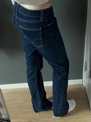 Mörkblå Levis bootcut jeans - Bootcut levis jeans🌟köpta secondhand men i bra skick. Midjemått 36 cm, innerbenlängd 76 cm. Jeansen är uppsprättade nertill som man kan se på bild 5. Ge prisförslag!