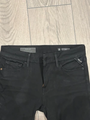 Svarta  jeans från Replay - Säljer ett par svarta skinny jeans från Replay med klassisk femficksmodell och diskreta detaljer. Jeansen har stretchigt material för skön passform och Replay-logga på fickan fram. Perfekta till en trendig vardagslook.