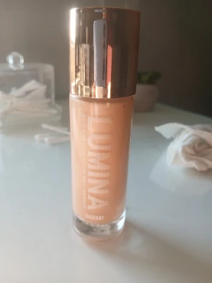 Lumina Radiant foundation glasflaska - Använd ca 3 gånger❤️ Foundation från Lumina i en snygg glasflaska med guldig lock. Färgen är en varm beige ton och formulan ger en strålande finish. Perfekt för dig som vill ha en naturlig glow och jämn hudton.