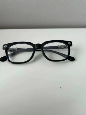 Chrome hearts glasögon  - Snygga svarta glasögon med rektangulära bågar i plast och coola stjärndetaljer i silver på hörnen. Perfekt accessoar för att lyfta din stil och ge en trendig touch till din look.