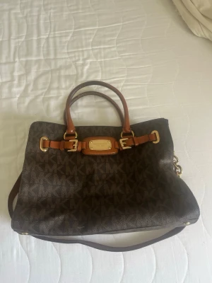 Michael Kors handväska  - Medelstor/stor handväska från Michael kors, jättesnygg men har legat i garderoben och inte kommit till användning, har smink fläck i men inget som syns.