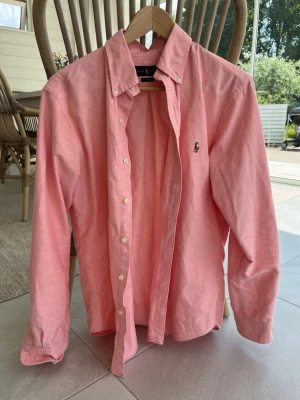 Ralph lauren skjorta  - Hej säljer en rosa Ralph lauren skjorta då den blivit för liten. Storlek M. Slim fit. Äkta. Hör av vid frågor. 