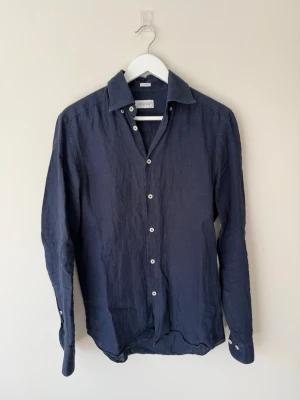 Mörkblå linneskjorta från These Glory Days - Snygg mörkblå skjorta från Three Glory Days i 100% linne. Köpt på Volt med passformen slim fit.