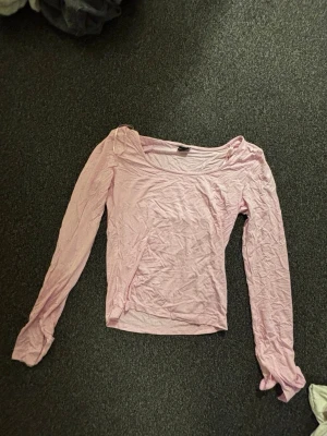 Ljusrosa långärmad topp - Söt ljusrosa långärmad topp med rund halsringning. Tunt och mjukt material som känns skönt mot huden. Perfekt att styla med jeans eller kjol för en chill look.