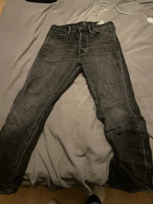 Svarta Acne jeans  - Säljer ett par svarta jeans från acne. Jeansen har en tvättad look och är tillverkade i kraftigt denimtyg. Perfekta för en avslappnad och stilren outfit. storlek 31 32 