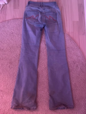 Ljusblå bootcut jeans med brodyr - Säljer ett par Nelly jeans, lite sönder längst ner men inget man tänker på. 