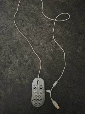 Vit gamingmus med USB-kabel - Säljer en vit gamingmus som har en lång USB kabel och har knappar på sidan och ett knapp i mitten av musen. Perfekt för dig som gillar att gamea plus den lyser med olika färger 