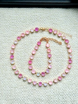Smycken till fest  - Säljer ett halsband och armband med gnistrande rosa stenar i olika nyanser. Stenarna sitter i guldfärgade infattningar och båda har ett justerbart kedjelås. Perfekt för dig som gillar färg och vill sticka ut lite extra.