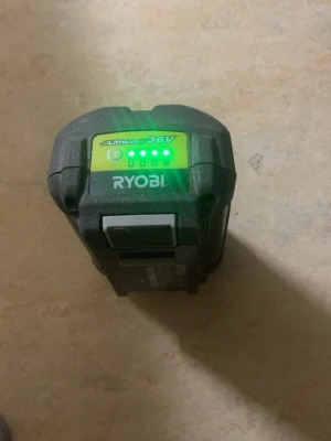 Ryobi 36V 5.0Ah Li-Ion batteri - Ryobi 36V 5.0Ah litiumjonbatteri, svart med grå och grön detalj. Batteriet har indikator för laddningsnivå och passar till Ryobis trädgårds- och elverktyg. Modell BPL3650D, robust design med tydlig märkning.