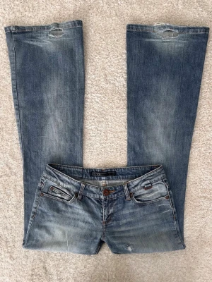 Blå Lowwaist bootcut jeans från Only - Supersnygga jeans från Only med slitningar och hål! Storlek 29/34❣️  Midjemått: 82 Innerbenslängd: 84 Grenhöjd: 19