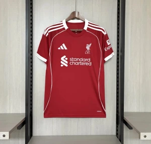 Liverpool FC röd matchtröja Adidas - Liverpool FCs officiella matchtröja från Adidas i rött med vita detaljer och tryck. Kortärmad modell med rund hals och klassiska Adidas-ränder på axlarna. Materialet är lätt och ventilerande polyester, perfekt för träning eller match. LFC-logga och sponsortryck på bröstet.