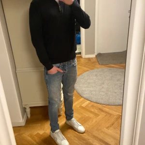 Dondup George  - Säljer ett par snygga ljusblå jeans från George med coola slitningar och detaljer vid fickorna. Jeansen har klassisk femficksdesign, kontrastsömmar och en straight passform. Perfekt för dig som gillar en avslappnad och trendig stil. Notera lite röd färg precis över ena knät( se bild 5) men inget som man märker tydligt.