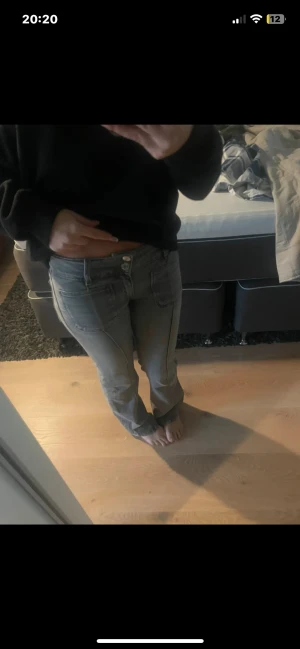 Ljusblå bootcut jeans med låg midja - STORLEK 146 Säljer ett par ljusblå jeans med låg midja och bootcut-ben. Jeansen har klassiska fickor fram och bak, samt synliga sömmar längs benen. Perfekta för dig som gillar en avslappnad och trendig look.