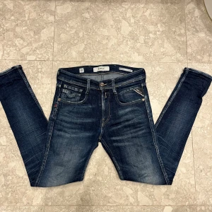 replay jeans - modell bronny lite tajtare än anbass Snygga mörkblå jeans från Replay med klassisk femficksdesign och coola detaljer på bakfickorna. Jeansen har en slim passform och är tillverkade i slitstarkt denim med snygga tvättade effekter. Perfekt för dig som gillar stilrena och moderna jeans.