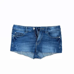 Blå jeansshorts med nitar - Snygga blå jeansshorts med rå kant och coola nitar på fickorna. Klassisk femficksmodell med knapp och dragkedja framtill. Perfekta för varma dagar när du vill ha en avslappnad och trendig look. Är i strl 152-158 men passar mig som är xs/34