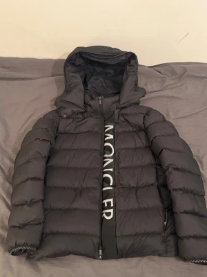Moncler Ume Jacka - En snygg och stilren svart Moncler Ume Reflektiv jacka. Den är välbehållen och knappt använd till ett bra pris. Obs priset är inte hugget i stenen. Byten till andra jackor är en möjlighet