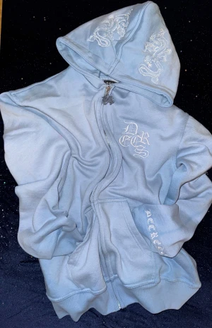 Decrese Sweden Ljusblå Hoodie – Modern och stilren komfort” - Stilren ljusblå hoodie i mjuk bomull med lätt stretch och oversize passform. Vit broderad logga framtill samt vita detaljer på huva och rygg. Stentvättad finish som ger en modern streetwear-look. Två framfickor. Mått: axel 46 cm, bröst 46 cm, längd 59 cm, ärm 60cm. Finns i XS–XXL. Skickas inom 1–2 dagar. ‼️Köparen står för returfrakt.‼️