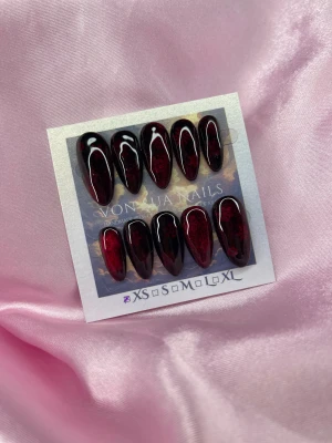 Snowflakes ❄️(XS);Medium Almond - Säljer ett set med handgjorda press-on naglar i en djup mörkröd cateye färg med glansig finish och subtila snöflingor som detalj. Naglarna är medium mandelformade och har storlek XS: 14 mm, 11 mm, 11,5 mm, 10 mm, 8 mm . Perfekt för dig som vill ha en dramatisk och snygg look.