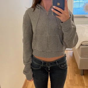 Brandy Melville hoodie - Säljer om denna söta croppade grå hoodien med dragkedja🩷 bara att kontakta vid frågor! Obs bilderna är lånade från tjejen jag hade köpt från😊