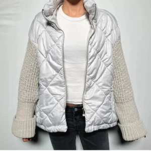 Quiltad silverjacka från Royal Cat - Säljer en unik quiltad jacka i silver från Royal Cat med stickade, ljusgrå ärmar och breda muddar. Jackan har dragkedja framtill och coolt rutmönster på kroppen. Perfekt för dig som vill sticka ut med en modern och mysig look. Säljer pga inte min stil längre💗💗