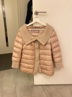 Beige pufferjacka från Herno - Säljer en beige pufferjacka från Herno med bred ribbad krage och muddar. Jackan har knappar framtill och är quiltad med en snygg, loose passform. Materialet är glansigt. Är i storlek 44 men passar från s - m. Säljer då den va lite stor på mig. Priset går att diskutera 