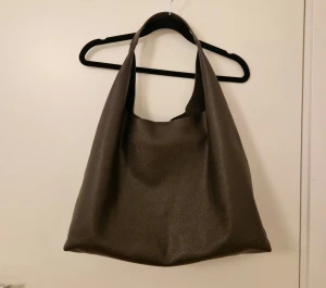 Brun axelväska i skinn från & Other Stories - Snygg och rymlig brun axelväska från & Other Stories i mjukt, strukturerat läder. Köptes på aboutyou för 1200kr för några månader sedan. Rymmer en mindre laptop.