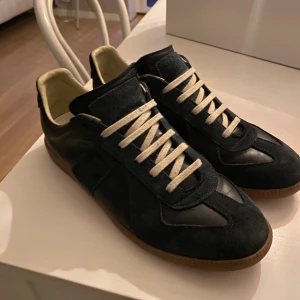 MM skor - Maison Margiela sneakers i blått med kontrasterande vita snören och beige insida. Skick 8/10 använda ett fåtal gånger men väldigt bra skötta. Strl 41 tveka inte på att höra av er