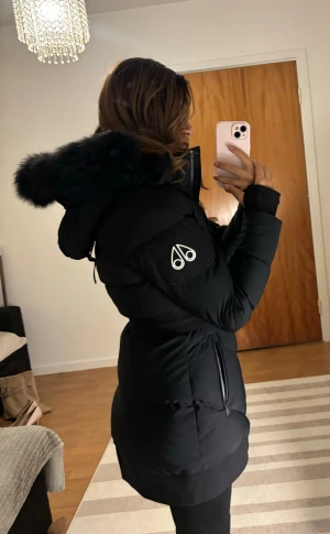 Moose Knuckles Limited Edition  - Svart dunjacka från Moose Knuckles med en vit detalj över bröstet och loggan på vänster ärm. Jackan har en avtagbar huva med svart päls. Den har även en dragkedja framtill och fickor med dragkedja på sidorna.  Jackan är använd max 3 gånger, köptes från thernlunds i Stockholm för 13 799kr. Kvitto finns. Storlek: XS