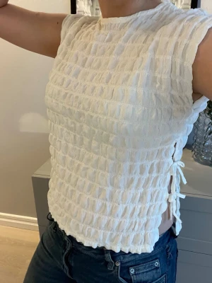 Vit strukturerad topp med knyt - Jättefin blus från Zara med knyten på sidorna. Strl 152 men skulle säga att den passar xxs-s!