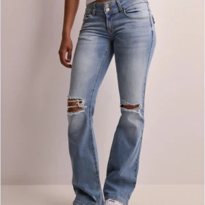 Bootcut jeans från Nelly - As snygga ljusblå jeans med bootcut och slitningar på knäna. Bra skick!! Tryck gärna på köp nu eller skriv vid frågor 💖