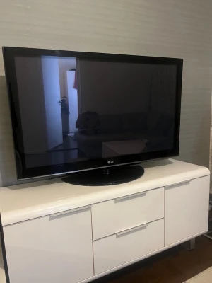 Svart platt-TV från LG och vitt - Säljer en svart platt-TV från LG med bred ram och stabil fot. Skärmen har en klassisk rektangulär form och passar perfekt för filmkvällar eller gaming. Enkel att placera på TV-bänk eller hänga på väggen. Perfekt till vardagsrummet eller sovrummet.