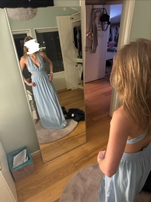 Ljusblå balklänning med öppen rygg - En jättefin ljusblå balklänning från Nelly. Min syrras klänning från hennes bal 2023, så om du vill ha en klänning som ingen annan har kan du nog räkna med det med denna klänning. Använd en gång, inga defekter! Köpt för 900kr 