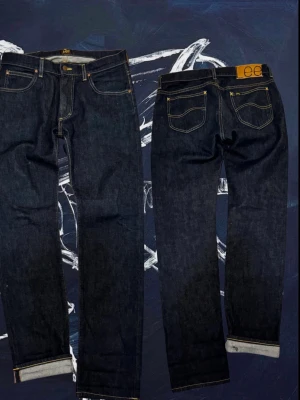 Selvedge Jeans från Lee🇯🇵🧶 - Säljer ett par mörkblå selvedge jeans från Lee med klassisk femficksdesign och raka ben. Jeansen har kontrastsömmar och en snygg läderpatch bak i midjan. Perfekta för dig som gillar en tidlös och clean look. Storlek 30/32. Skriv för mer info!