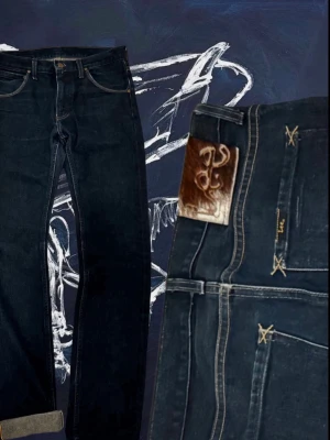 Selvedge Jeans från Lee med Cowpatch🐄 - Säljer ett par mörkblå selvedgejeans från Lee med klassisk rak passform och snygga kontrastsömmar. Jeansen har uppvikta benslut, läderpatch med koskinn bak och detaljerade bakfickor. Perfekta för dig som gillar streetwear/archive och vill sticka ut. Storlek 30/34. Skriv för mer info!
