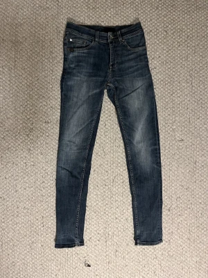 Tiger of Sweden slim jeans blå - Säljer ett par snygga blå jeans från Tiger of Sweden. Modellen är slim fit med smala ben och klassisk femficksdesign. Jeansen har en mörk tvätt med lätt slitning och är gjorda i mjukt denimtyg. Perfekta till sneakers eller boots. Hör av er om frågor om storlek,