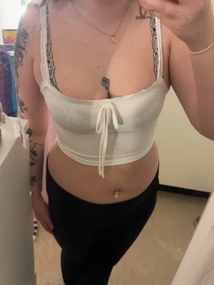 Vit croppad linnetopp med knyt - Snygg vit croppad linnetopp med smala axelband och knyt framtill. 