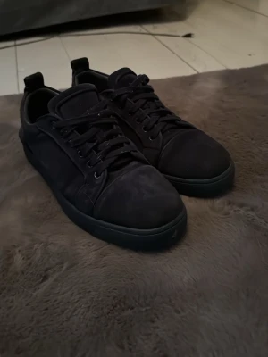 Svarta sneakers i mocka - Stilrena helsvarta sneakers med ovandel i mocka och matchande svarta skosnören. Låg modell med diskret design och gummisula. Perfekta för dig som gillar en clean och enkel look.