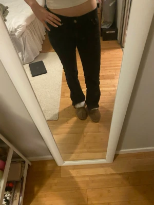 Svarta bootcut jeans med låg midja - Snygga svarta jeans med bootcut-modell och låg midja. Lite urtvättade men fortfarande fina, ner trampade på ena benet då de är för långa