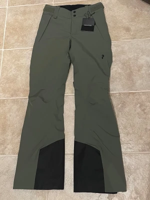 Nya gröna skidbyxor från Peak Performance - Oanvända gröna skidbyxor från Peak Performance HIPE. Är 164 cm lång för referens. Justerbara i midjan. Nypris 3000. Strl xs