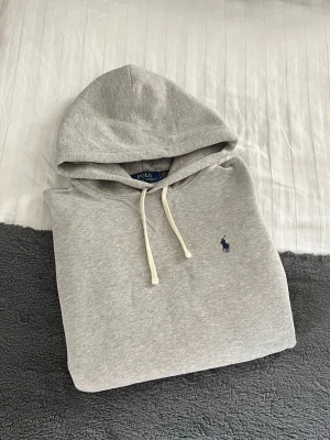 HELT NY! Grå Ralph Lauren Hoodie  - Grå Ralph Lauren Hoodie i Nyskick🔥. Storlek S, kan även passa en större XS. Hör gärna av er vid funderingar! Perfekt för vinterkylan ☃️🧣