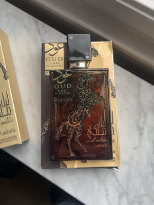 Oud Lail Maleki Eau de Parfum - Oud Lail Maleki från Lattafa är en Eau de Parfum med en unik design och lyxig känsla. Perfekt för dig som vill sticka ut med en elegant och modern doft. Flaskan har ett coolt hästmotiv och kommer i en snygg förpackning. Runt 70ml kvar  kom med bud