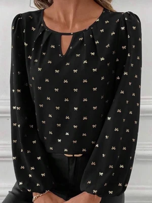 Svart blus med små rosetter - Snygg svart blus med små guldfärgade rosetter över hela tyget. Blusen har rund halsringning med en liten nyckelhålsöppning framtill och långa puffiga ärmar med resår vid handlederna. Tillverkad i ett lätt, flytande material som ger en elegant look.