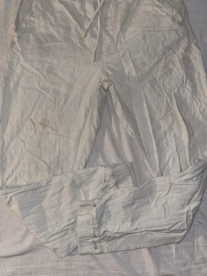 Linne byxor från Zara - Säljer ett par linnebyxor med dragsko i midjan och muddar vid bensluten. Byxorna har en avslappnad passform och är perfekta för chill dagar. Tillverkade i mjukt bomullsmaterial för extra komfort. Vid fundering tveka inte på att höra av dig!