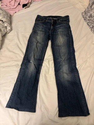 Blå flared jeans - Det står inget märke och ingen storlek då det är gamla. Midja måttet rakt över är 33cm och innerbenslängden är 68 cm. Det är inte en låg midja utan ungefär mid waist!