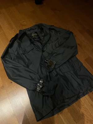 Field jacka - Next - Säljer denna fina mörkgråa / silvriga tunna fieldjackan från Next!🙌🏻 || skick: Skicket är 9/10 förutom en trasig knapp på ena ärmen (bild 5) || Storleken: M || Priset: 249kr (nypris 1000kr+) || Hör av dig vid funderingar!